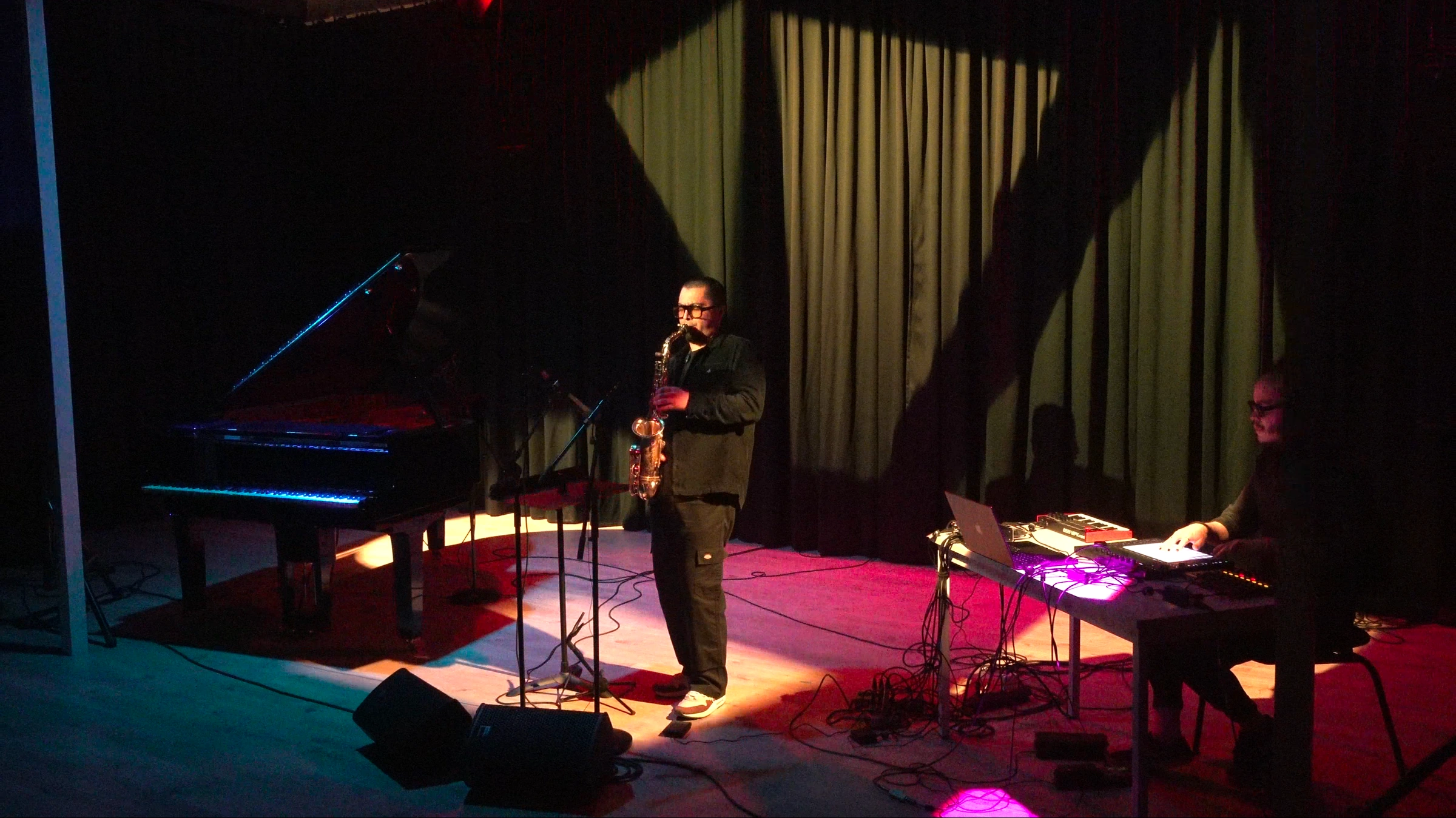 Des Visages performing with saxophone and electronics on stage.